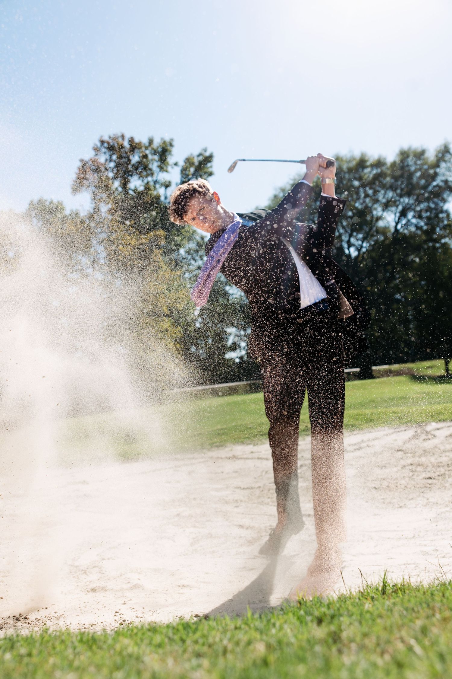 Senior guy Golfer hitting ball from sand trap creating dramatic spray.  Middle TN senior photographer.