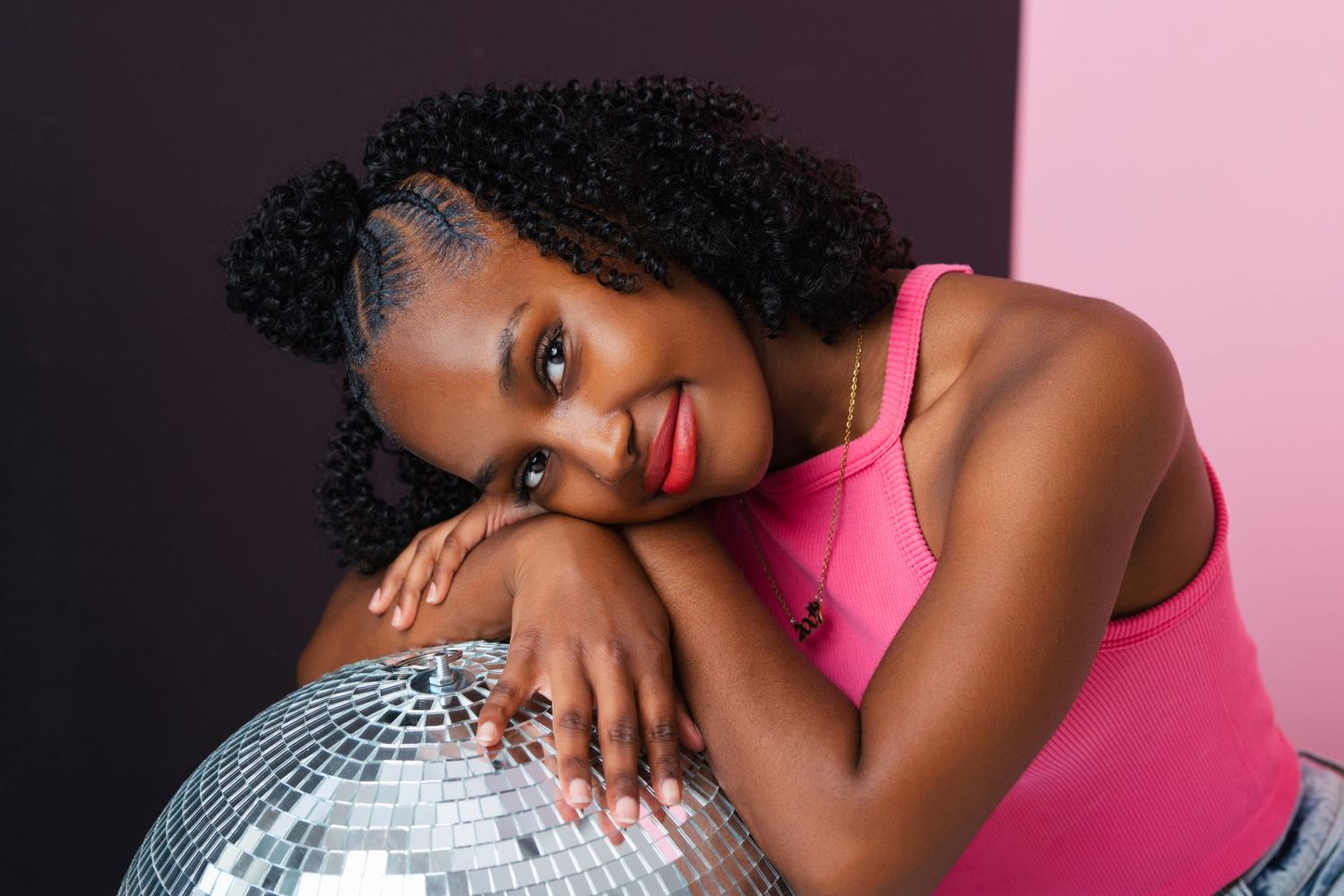Studio portrait with a glittering disco ball and bright pink top. Middle TN senior photographer.