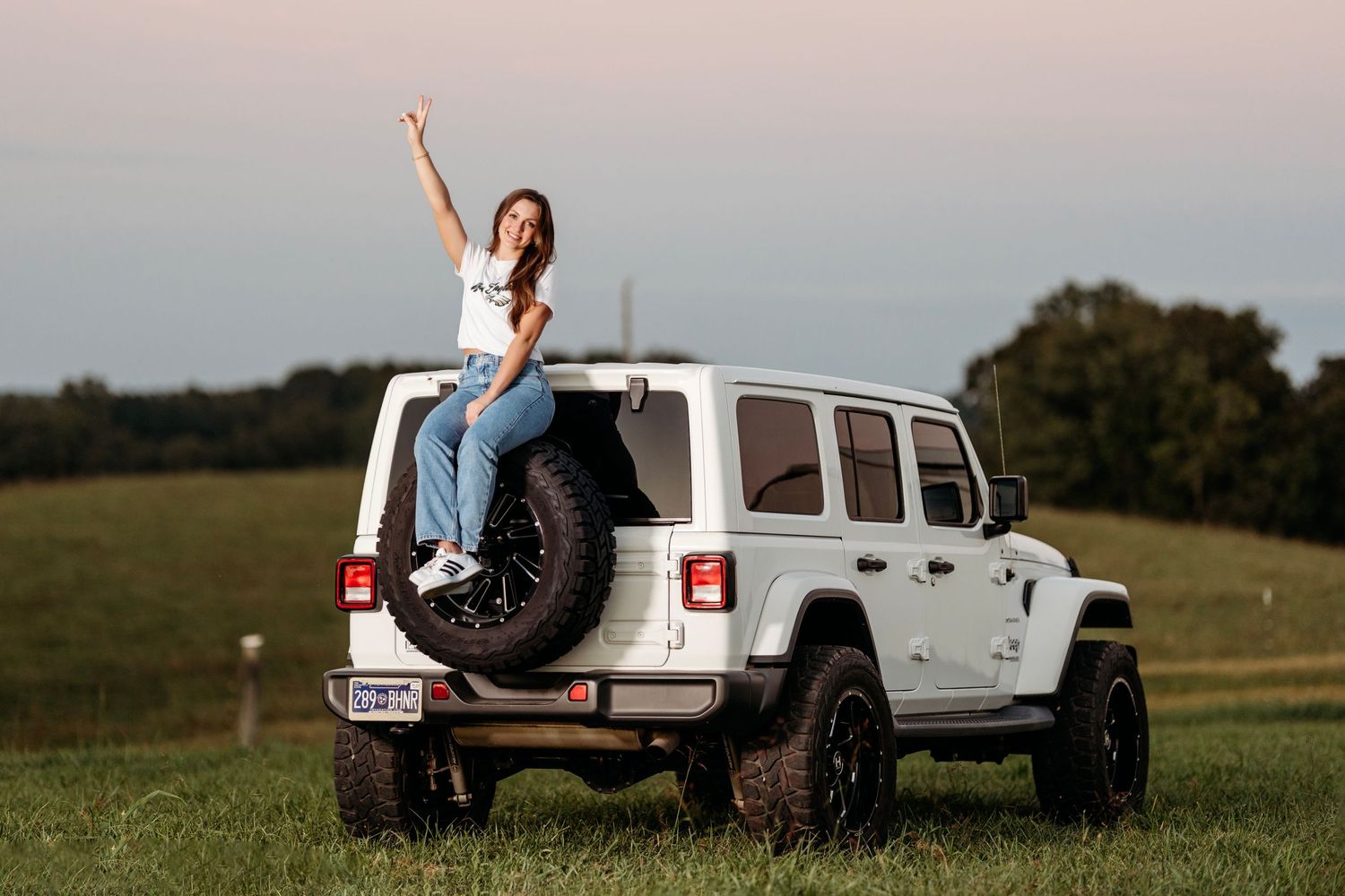 White Jeep provides rustic backdrop for sunset portrait session in open field. Middle TN Senior photographer