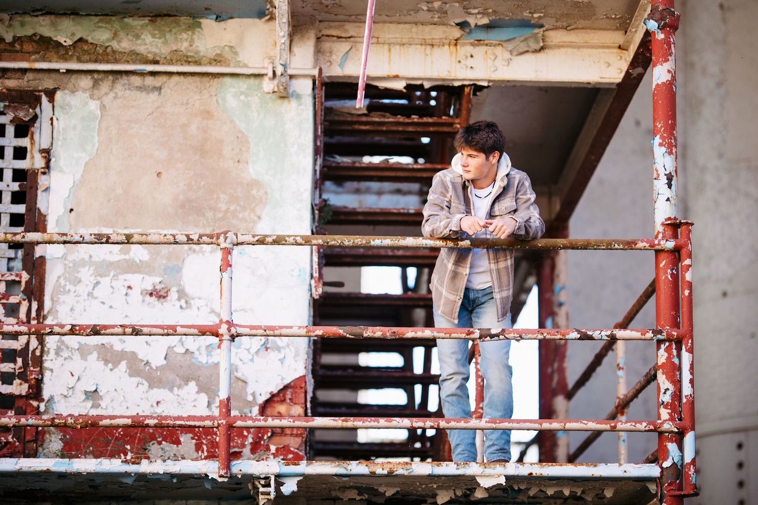 Senior guy on scaffolding with exposed brick wall background Nashville.  Middle TN senior photographer.