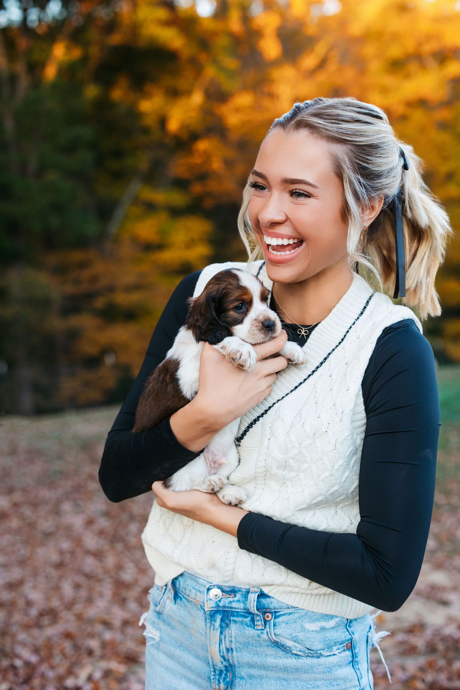 Autumn outdoor photoshoot with small puppy and casual outfit among fallen leaves. Middle TN senior photographer.