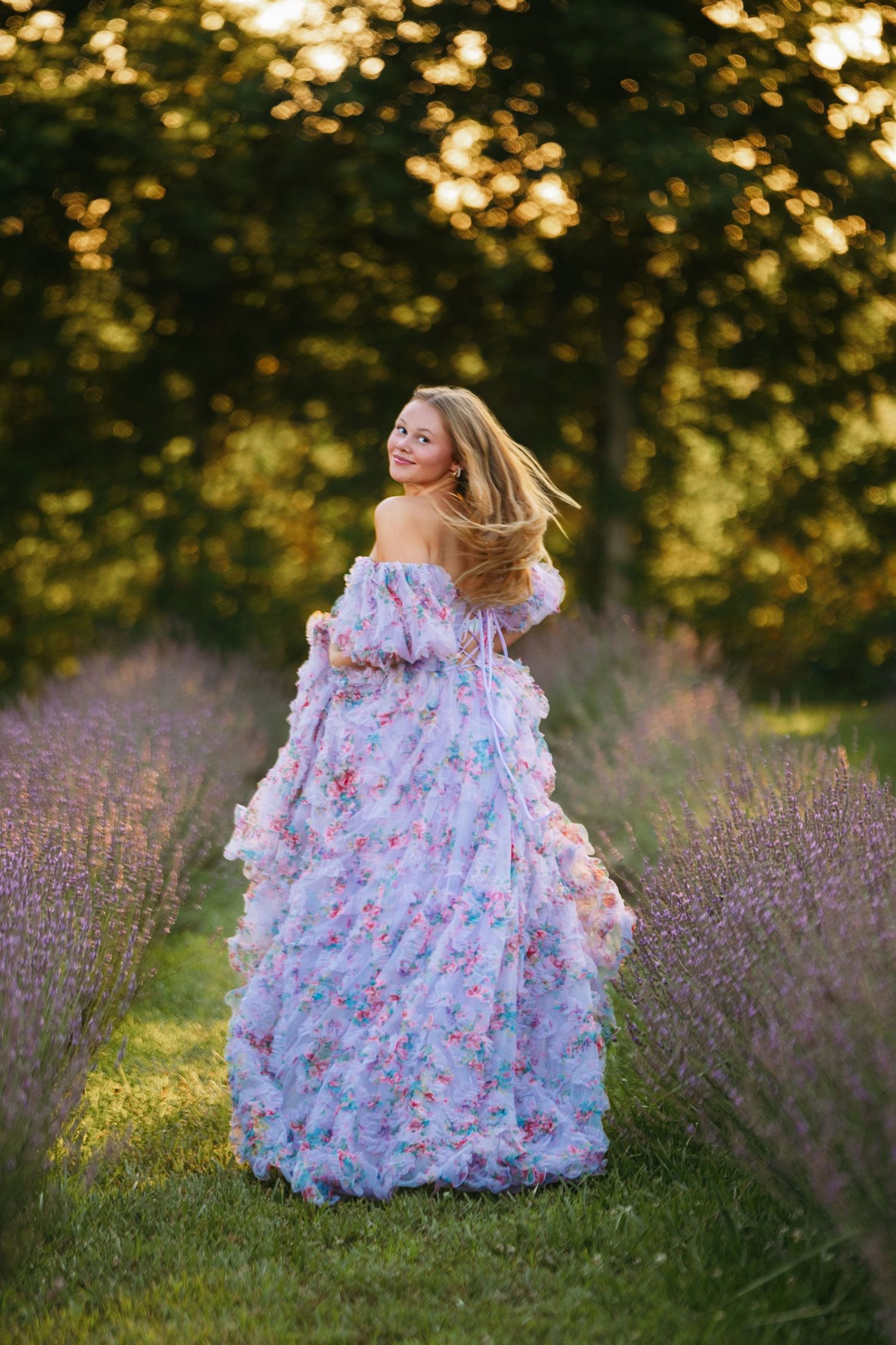 A flowy floral dress twirls gracefully in a lavender field at golden hour.