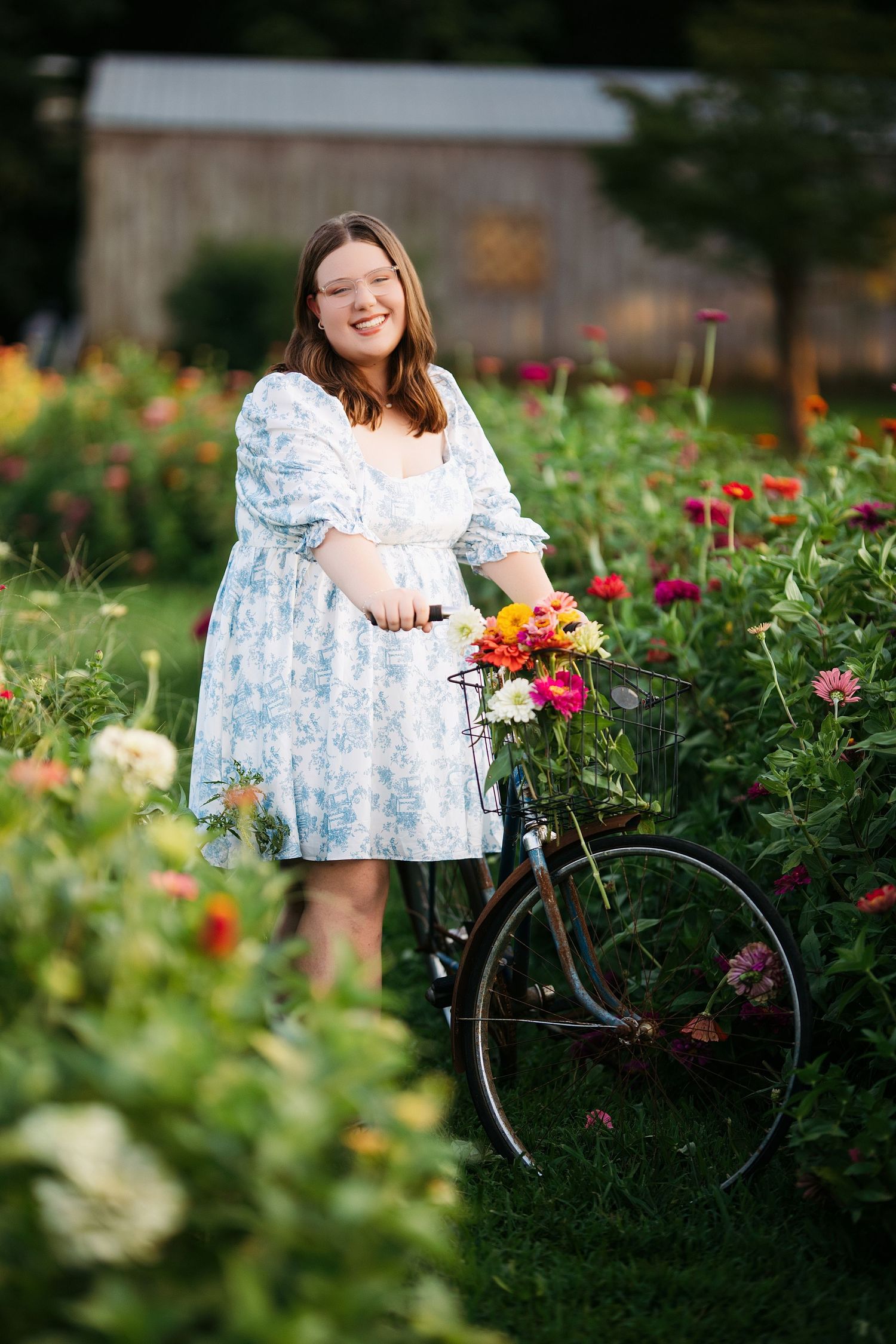 Garden photoshoot featuring a vintage bicycle among blooming flowers. Middle TN senior photographer.