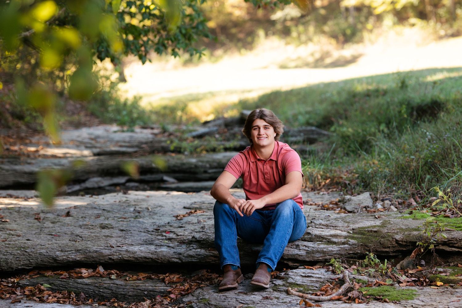 A casual outdoor portrait taken on natural rock formations in warm sunlight.  Middle TN senior photographer.