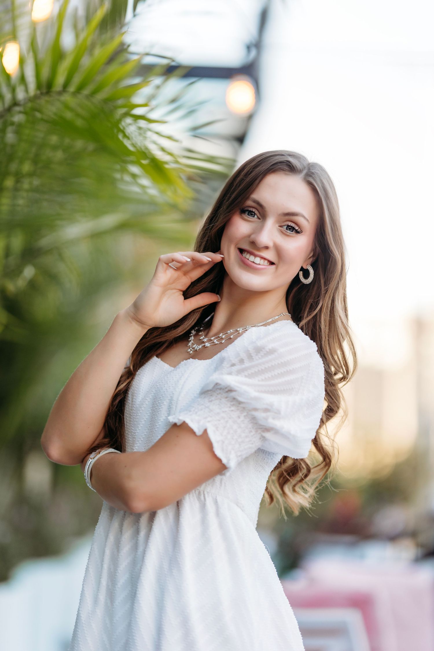 Bright white summer outfit captured against tropical palm leaves and soft lighting. Middle TN Senior photographer
