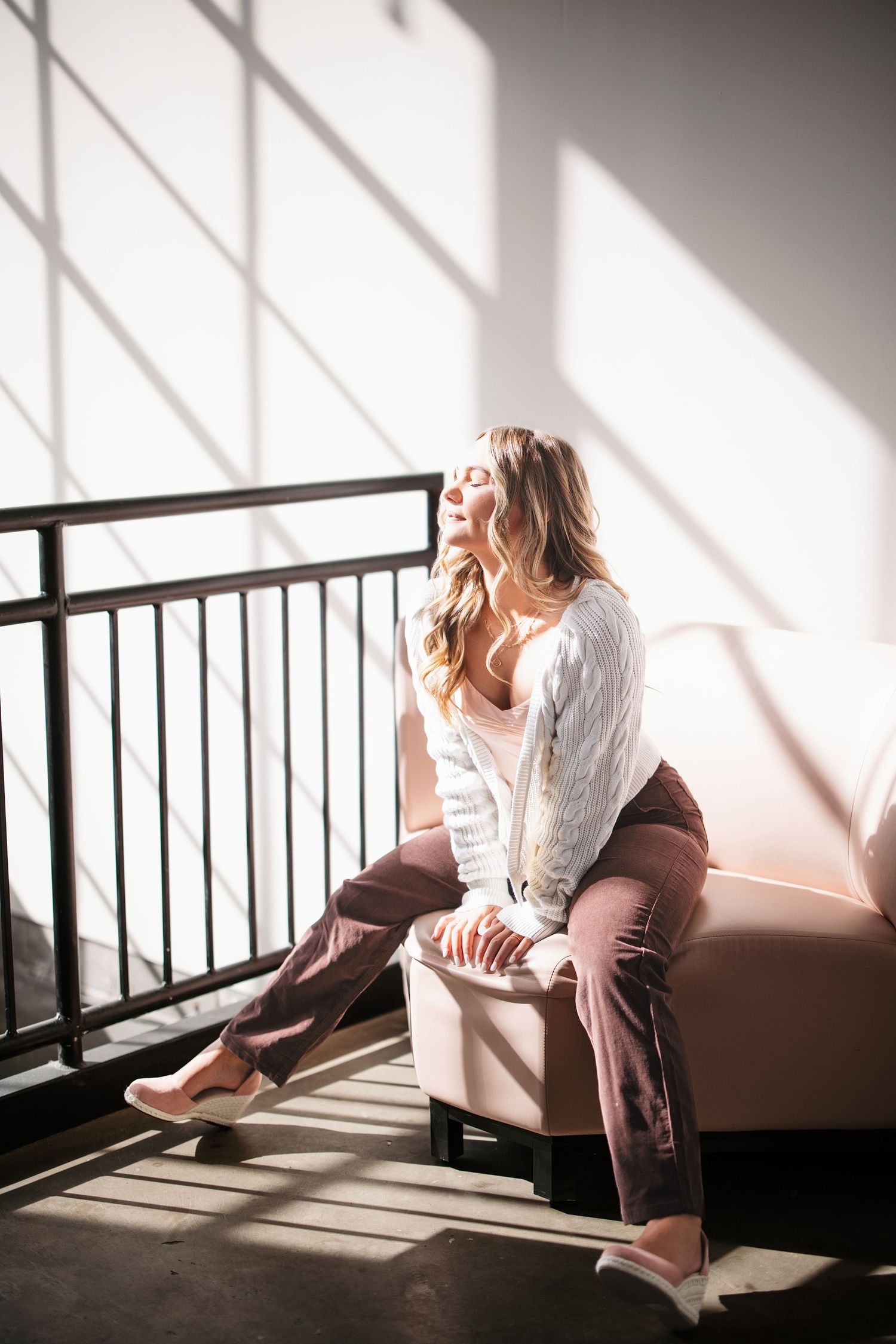 Moody indoor portrait with dramatic window lighting and shadow patterns. Middle TN senior photographer.