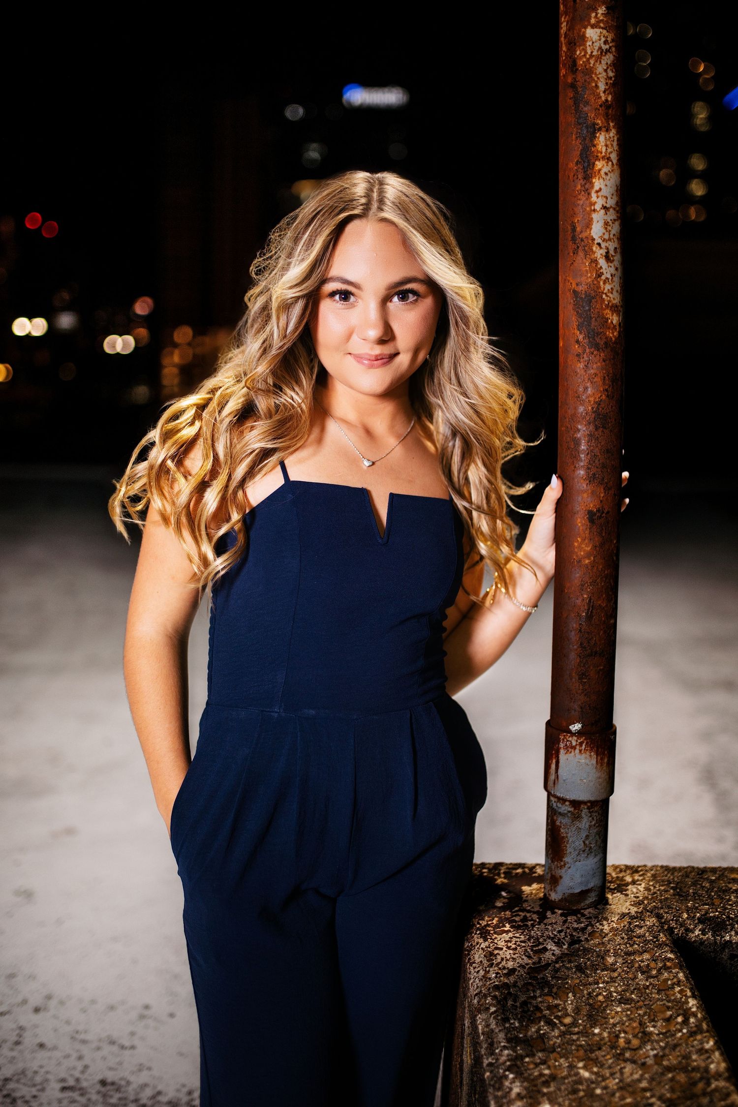 Evening portrait session with navy blue formal dress against industrial backdrop. Middle TN senior photographer.