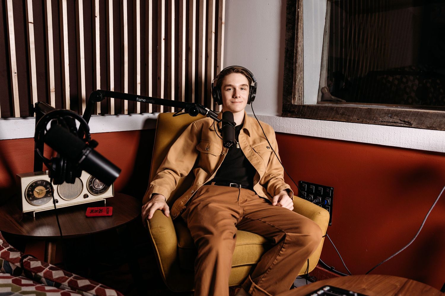 Senior relaxing on red couch in casual attire shown in recording studio photos.  Middle TN Senior photographer