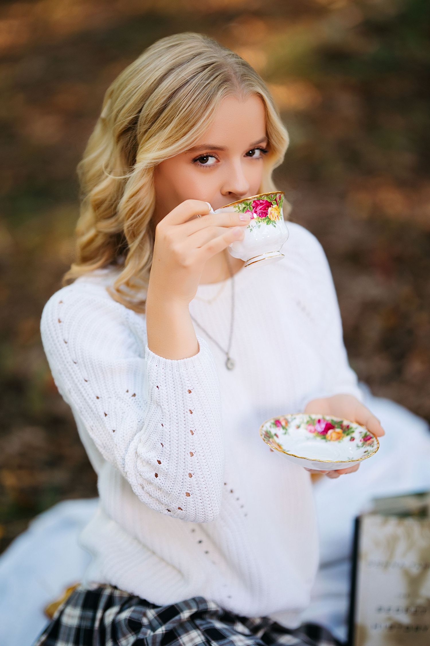 Vintage-inspired tea party setting with white lace dress and delicate floral details. Middle TN senior photographer.