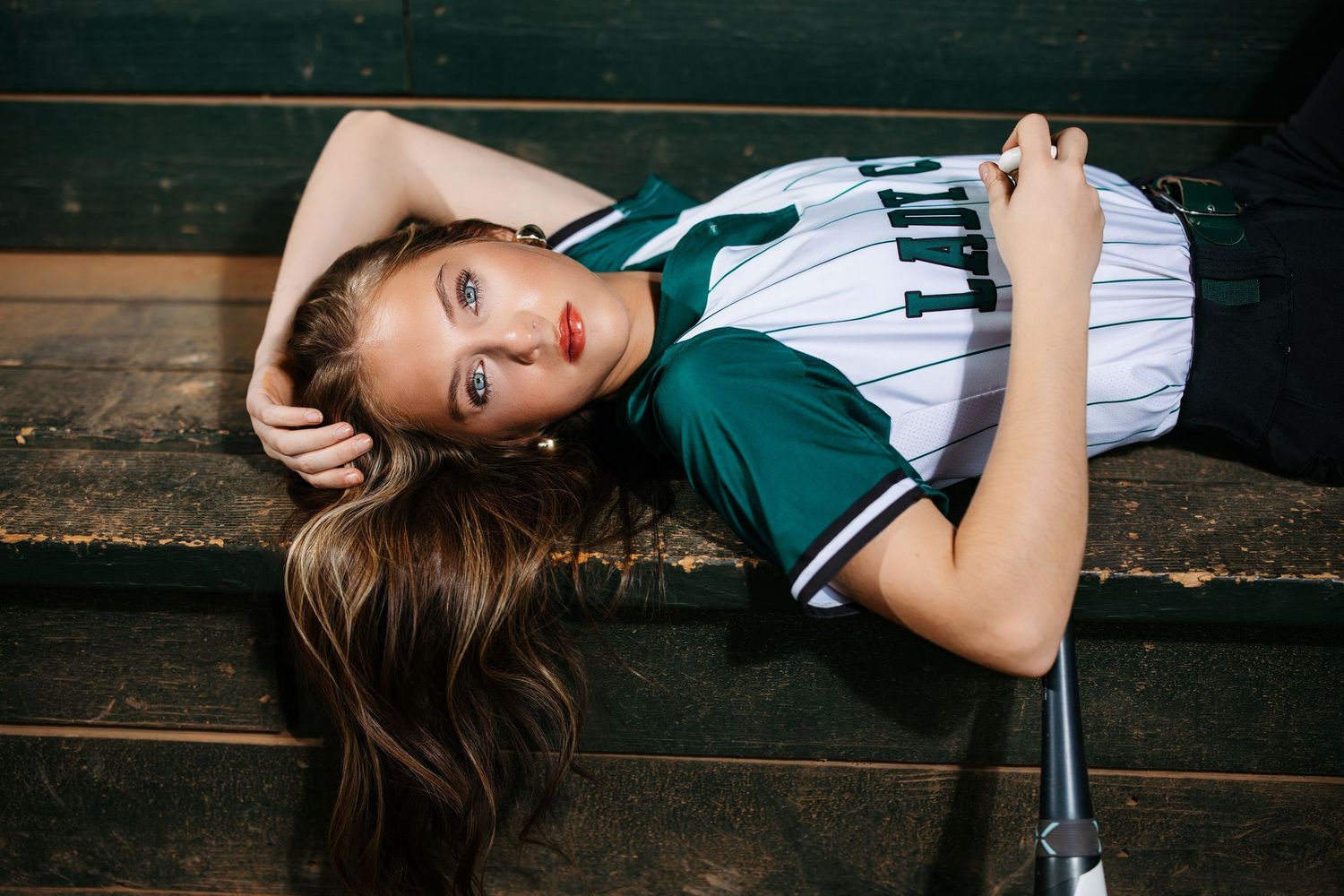 A series of artistic portrait photographs showing a person in a striped shirt reclining on a dark wooden surface.