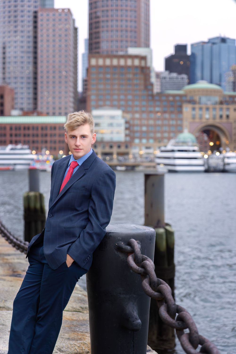High school senior boy in a suit for a photoshoot downtown Boston Massachusetts at Fan Pier Park