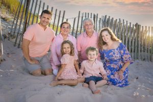 Multi-generational family photoshoot on a beach with grandparents, parents, and children