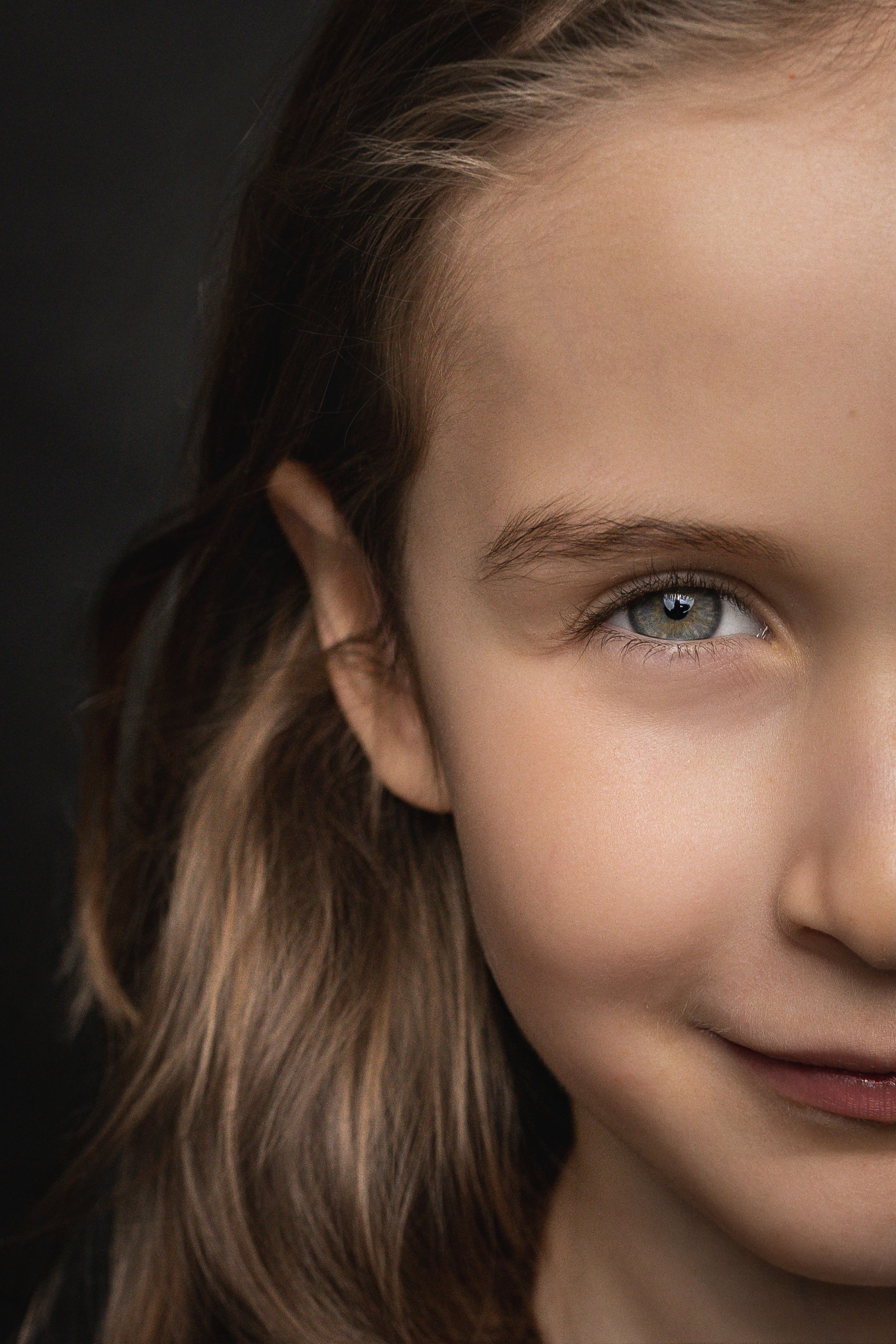 A series of cropped portrait photos showing parts of a face with blue eyes and brown hair in dramatic lighting.