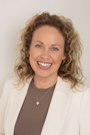 Professional headshot series showing confident expressions in white blazer and brown top with curly hair.