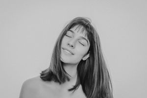 Black and white portrait series showing a person with long hair in various poses with eyes closed and serene expressions.
