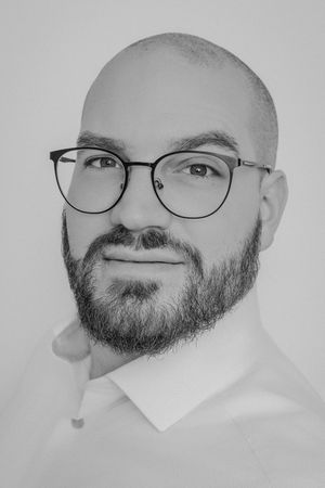 Black and white portrait series showing a bald man with glasses and beard making different expressions.