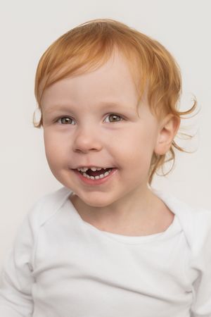 A series of four close-up photos showing a child with red hair in a white shirt making playful expressions.