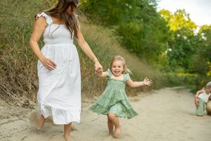 A series of candid outdoor photos showing people in white and mint green dresses walking along a sandy path in nature.