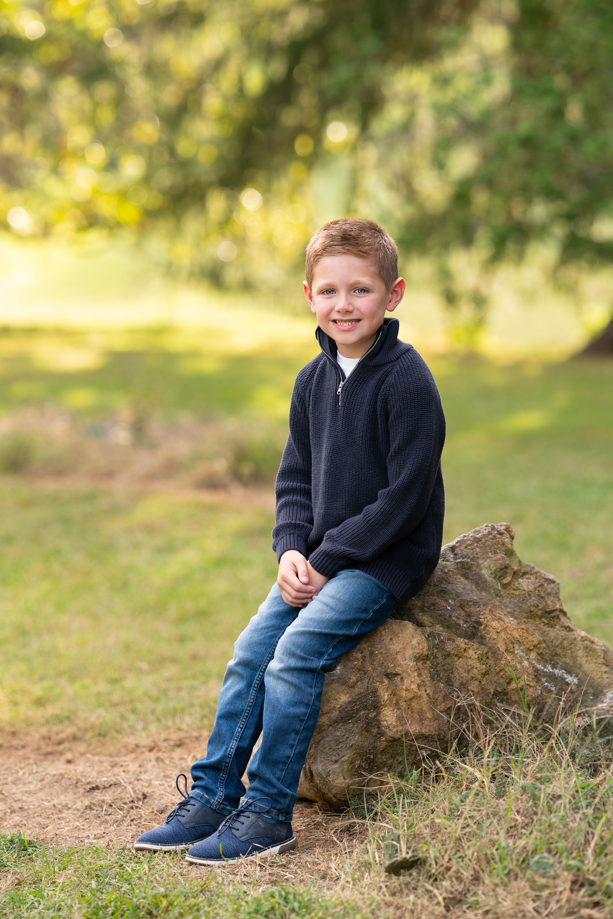 young boy smiles for camera in outdoor portrait