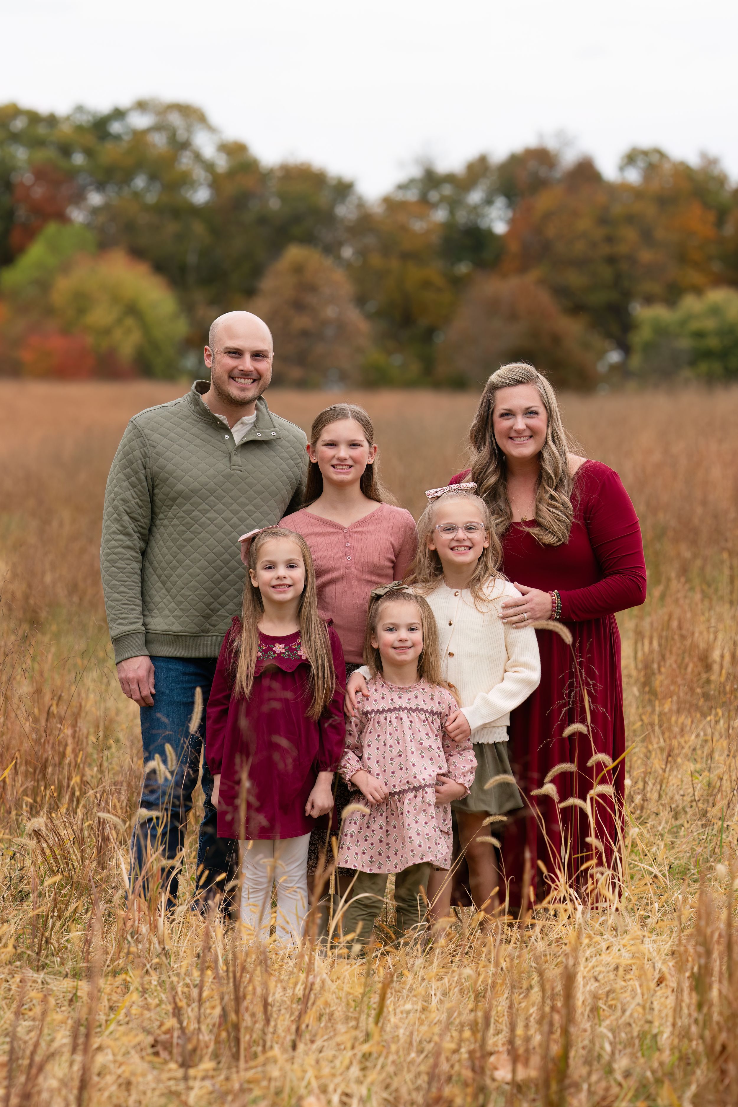 Family poses in grassy field
