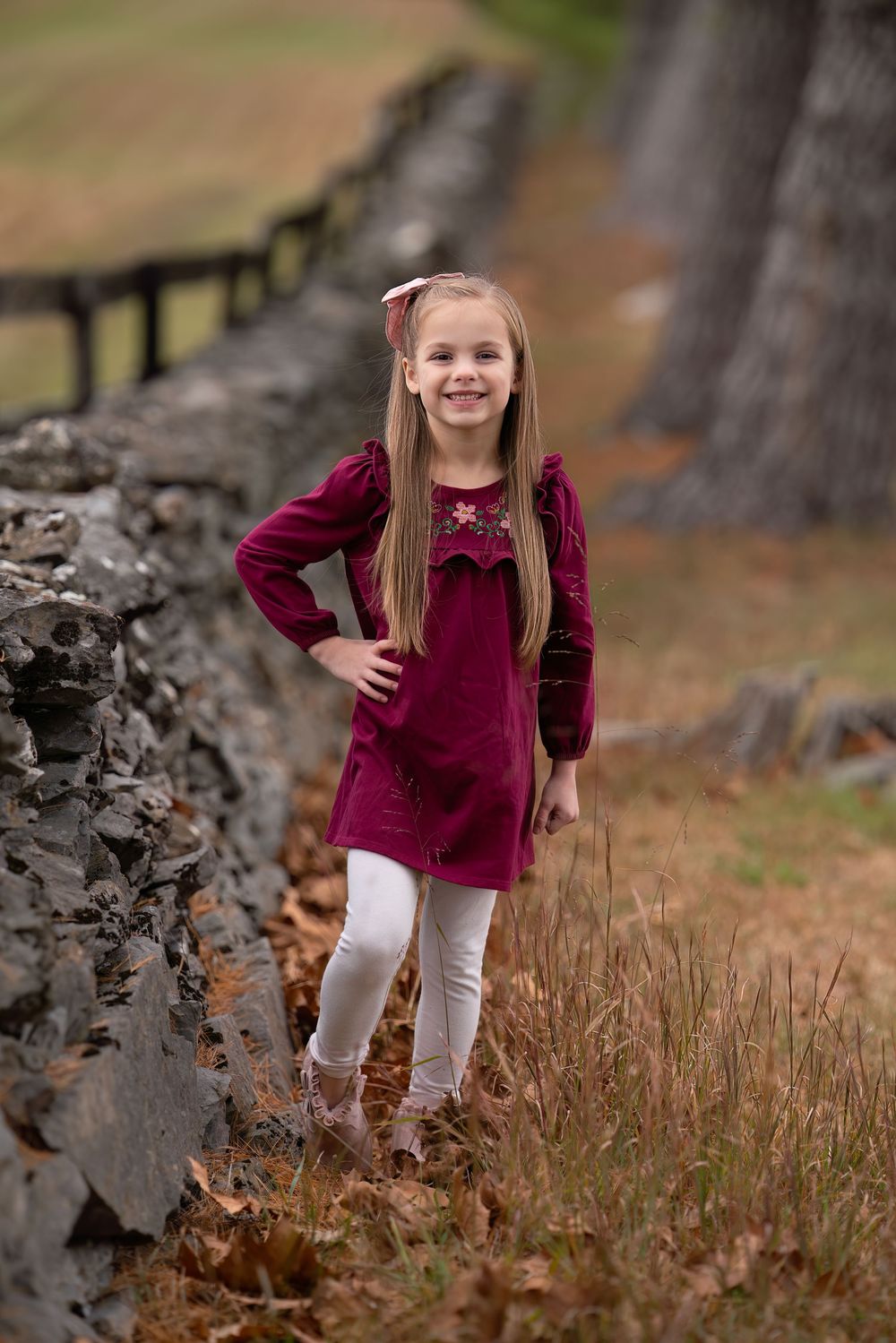 girl stands next to stone wall at VA State Arboretum