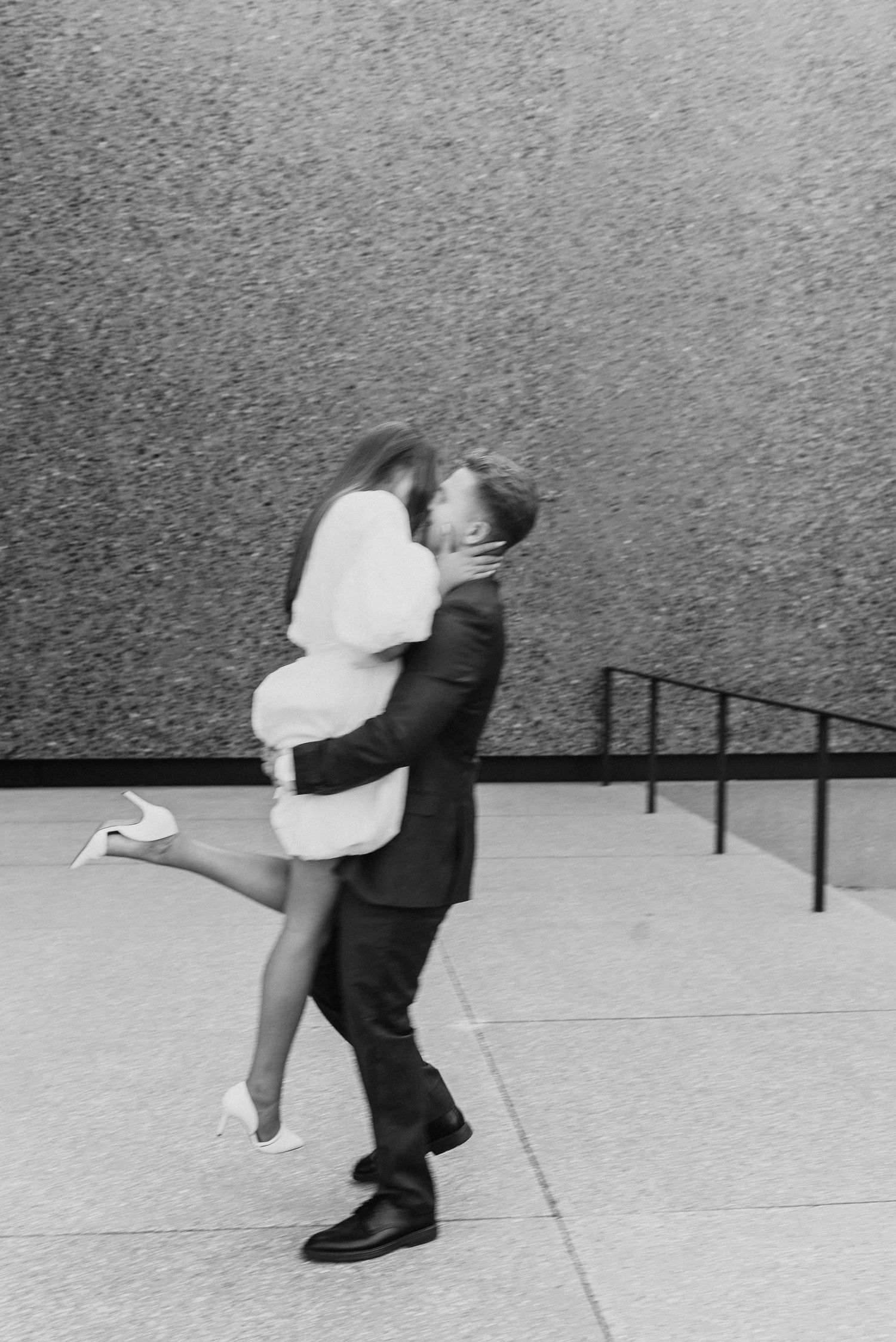 A romantic black and white sequence shows a couple dancing and dipping on a concrete surface.