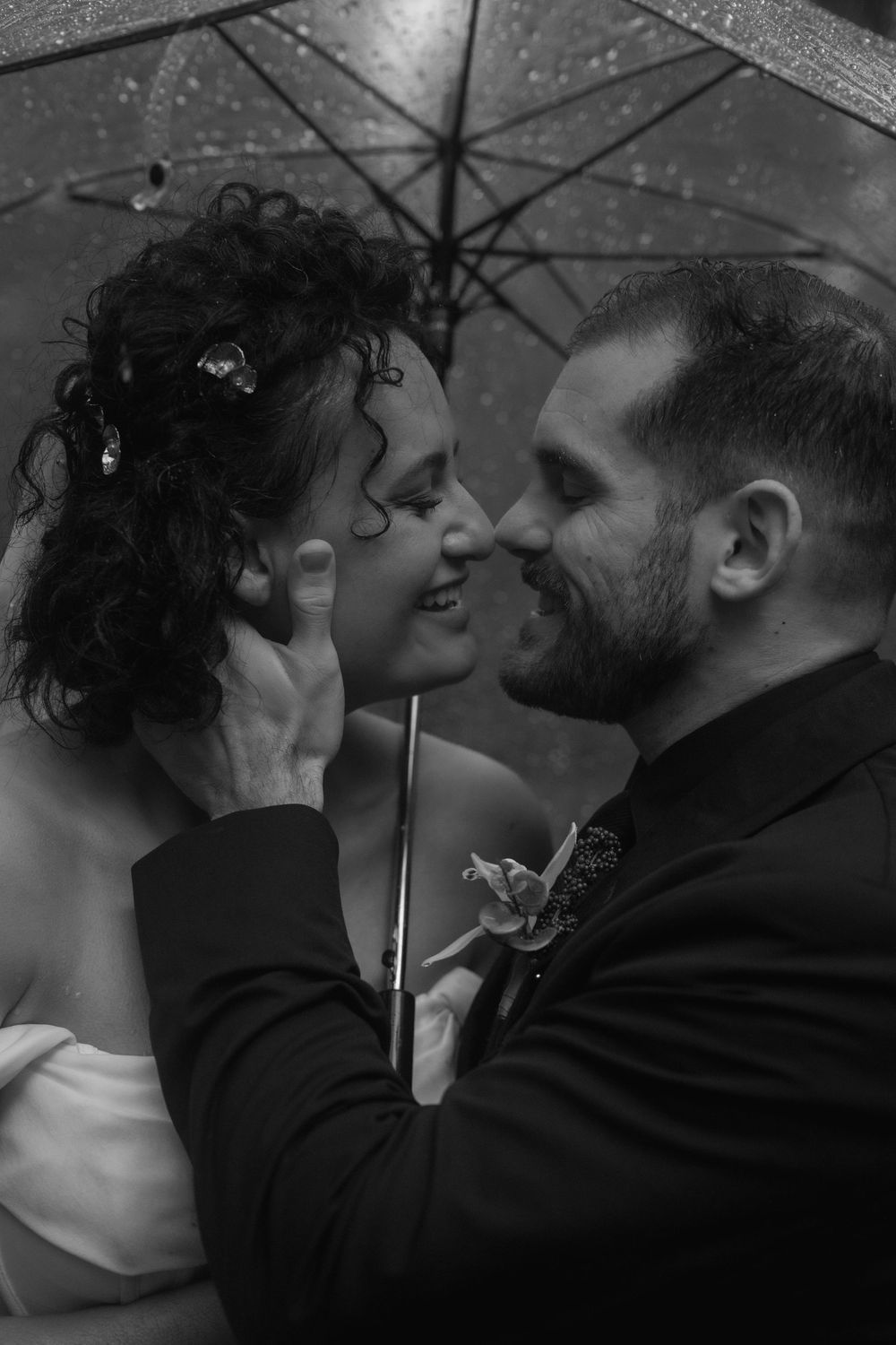 A romantic black and white photo sequence shows a couple sharing an intimate kiss under an umbrella in the rain.