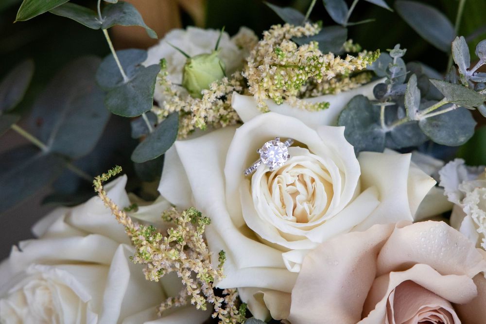 Elegant white roses with delicate elderflower blossoms arranged in a romantic wedding floral design.