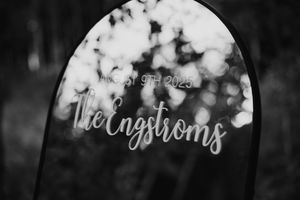Black and white photo of an engraved acrylic wedding sign reading The Engstroms, August 9th 2025.