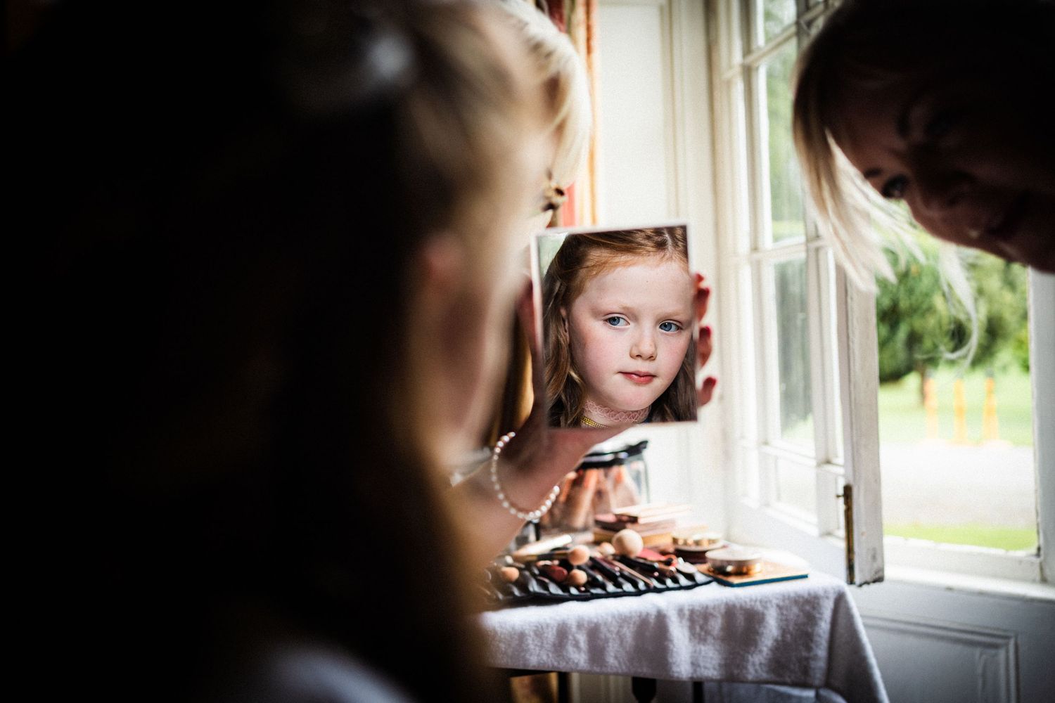Artistic window portrait capturing soft natural light and reflection.