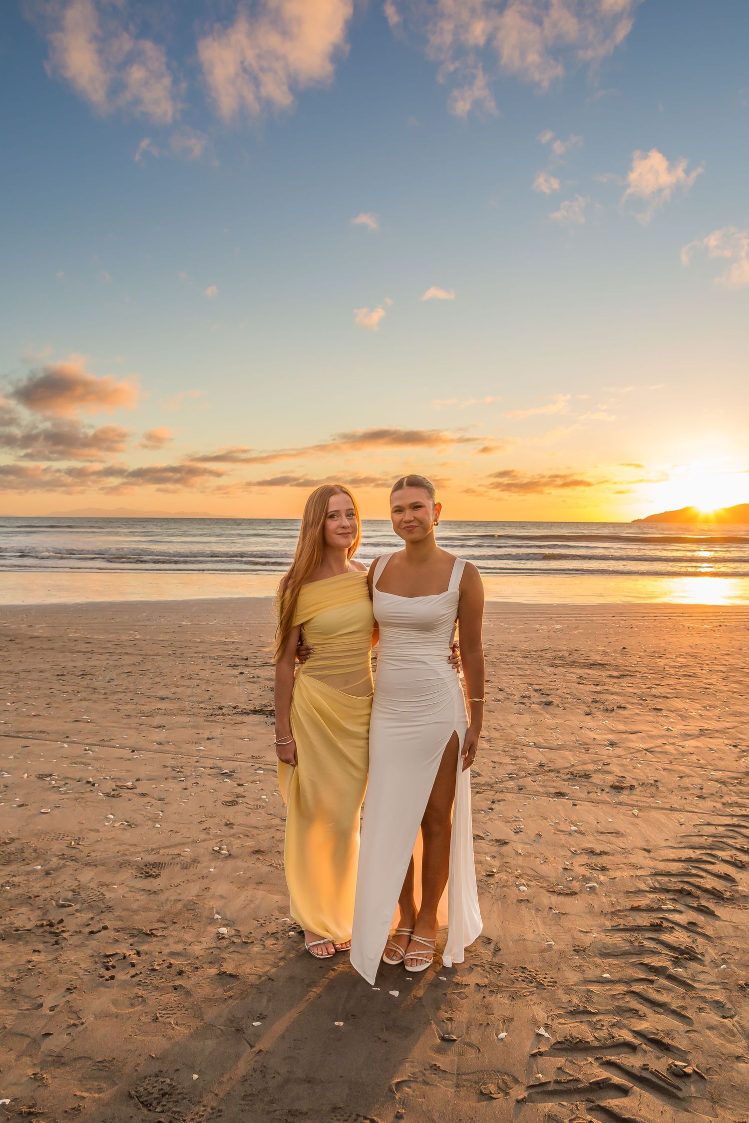 A silhouetted figure stands triumphantly on a cliff edge against a golden sunset over the ocean.