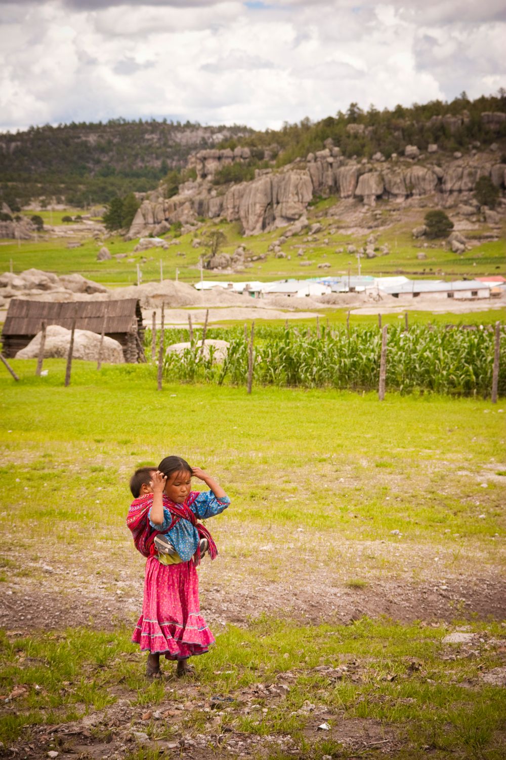 La Sierra Tarahumara, ChihuaTraditional scene in a rural valley with colorful clothing against rocky mountain backdrop.
