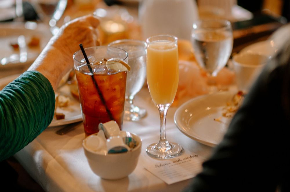 Elegant brunch table setting with a mimosa, iced tea, and water glasses at a fine dining restaurant.