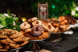 Dessert table with chocolate sprinkle donut, cookies, and pastries at an elegant event.