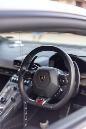 Interior view of a Lamborghini Huracan showing the iconic steering wheel and cockpit dashboard.