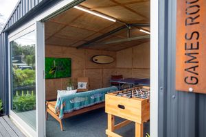 Modern games room in a container conversion featuring foosball table and daybed with sliding doors.