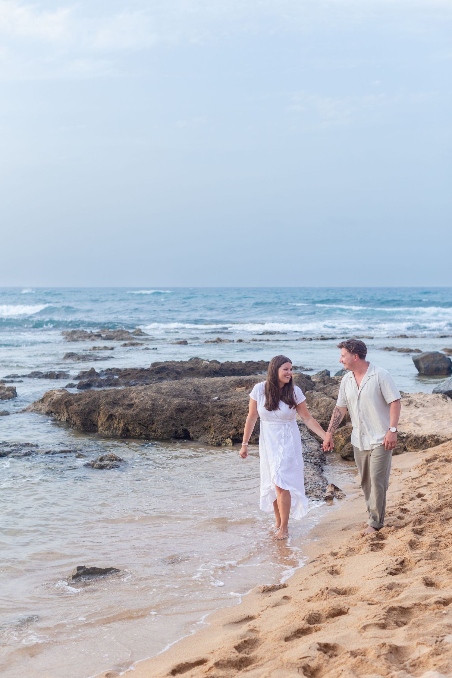 Couples portrait walking along the beach at Balneario del Escambrón in Old San Juan, Puerto Rico.