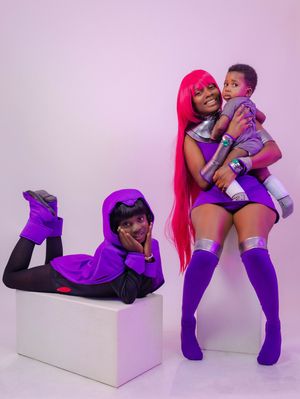 Three people in purple Teen Titans cosplay costumes pose together, including Raven and Starfire characters.