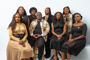 A group of eight Black adults posing together for a professional portrait against a white background.
