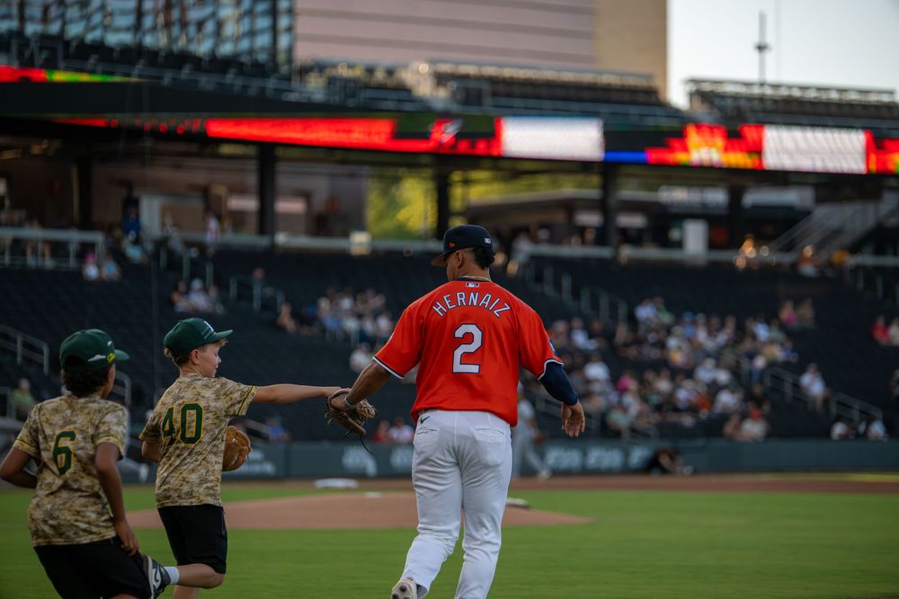 Baseball player #2 Herrera in red uniform jogs on field during a game at a professional stadium.