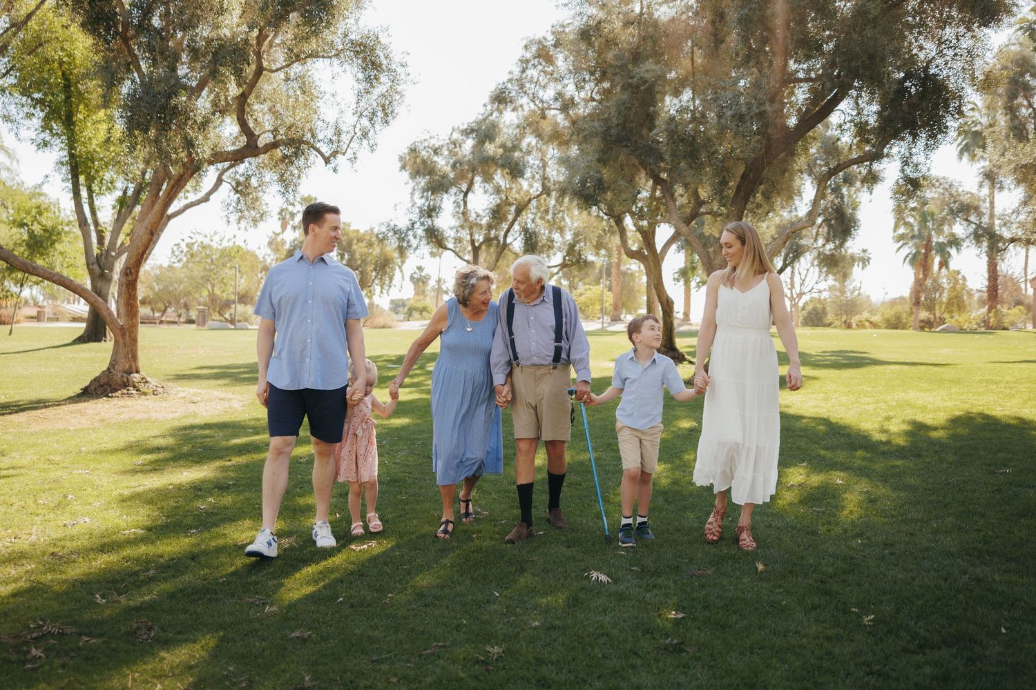 Family of six poses among Joshua trees at golden hour in the desert, wearing rich jewel-toned velvet outfits.