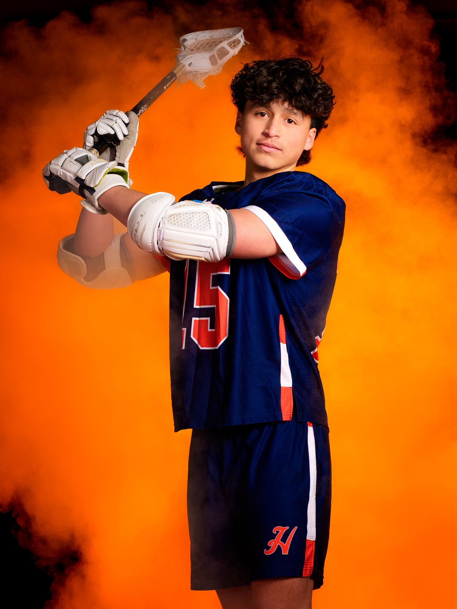 Hershey lacrosse senior 2026 portrait with stick and orange smoke, by Deanna Fox, SportsFox Photography based in Hershey PA