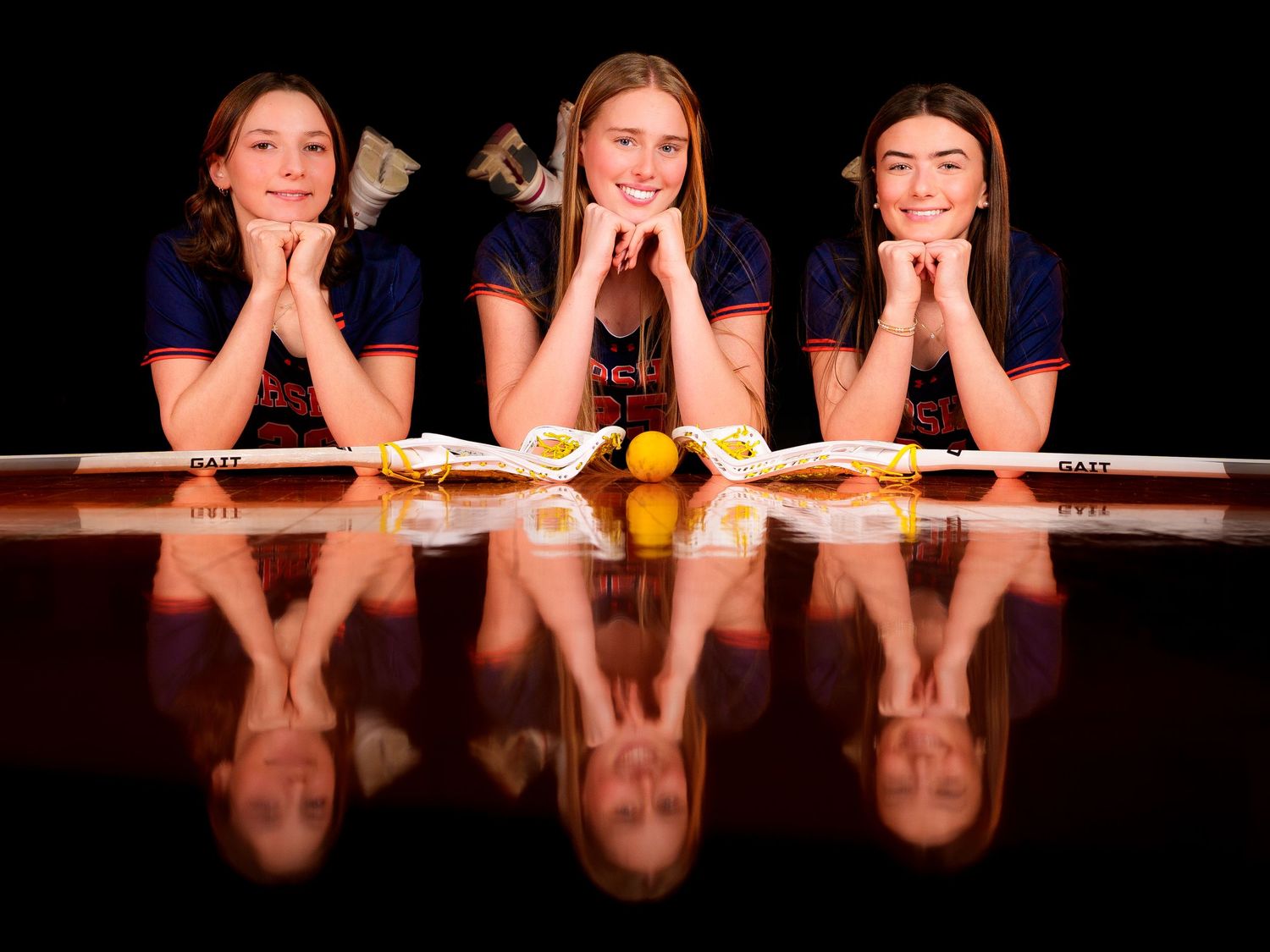 Three Hershey lacrosse seniors in a 2026 reflection portrait, by Deanna Fox, SportsFox Photography based in Hershey PA