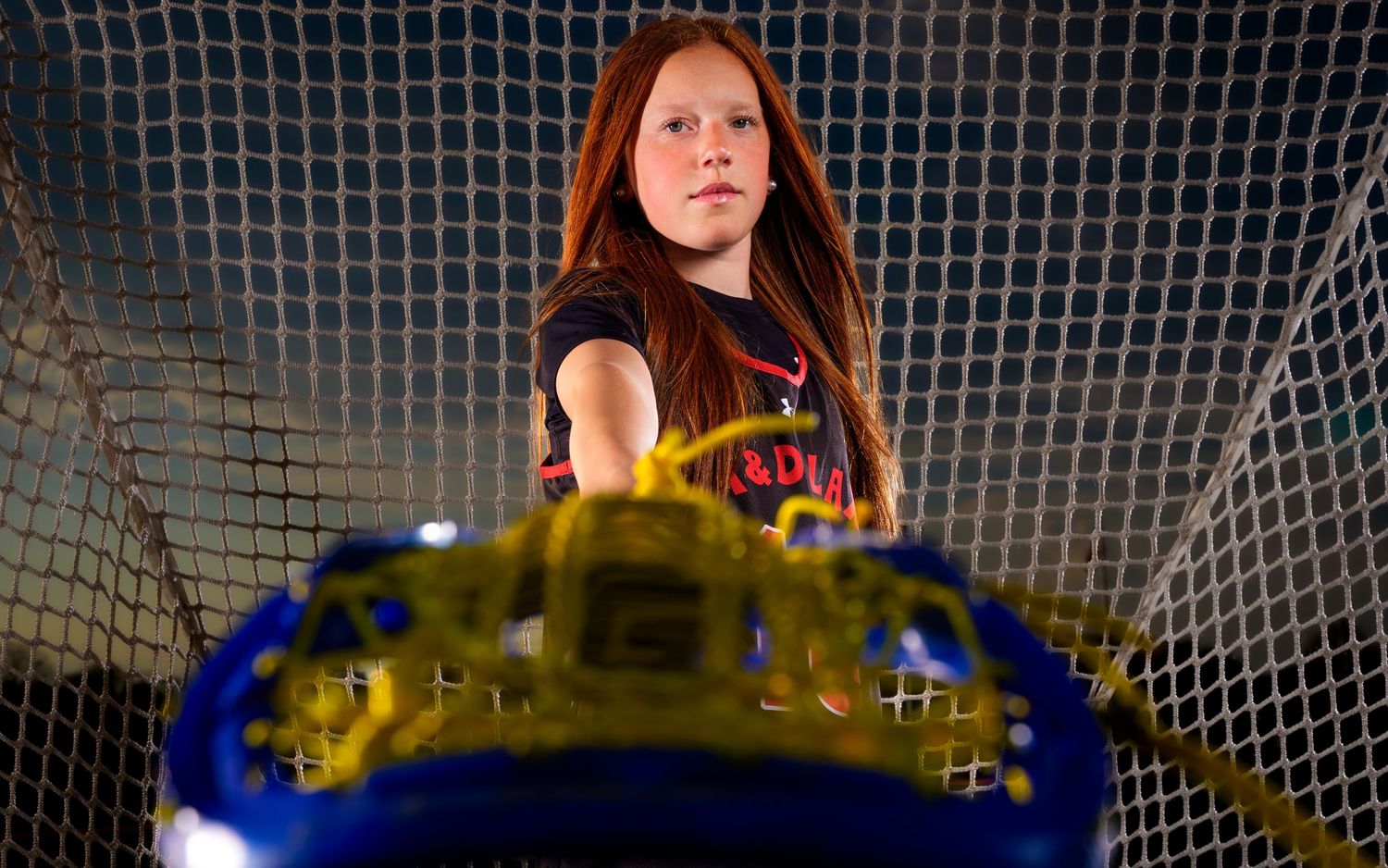 Regan Fedash M&D club lacrosse Media Day portrait framed through her stick, by Deanna Fox, SportsFox Photography based in Hershey PA
