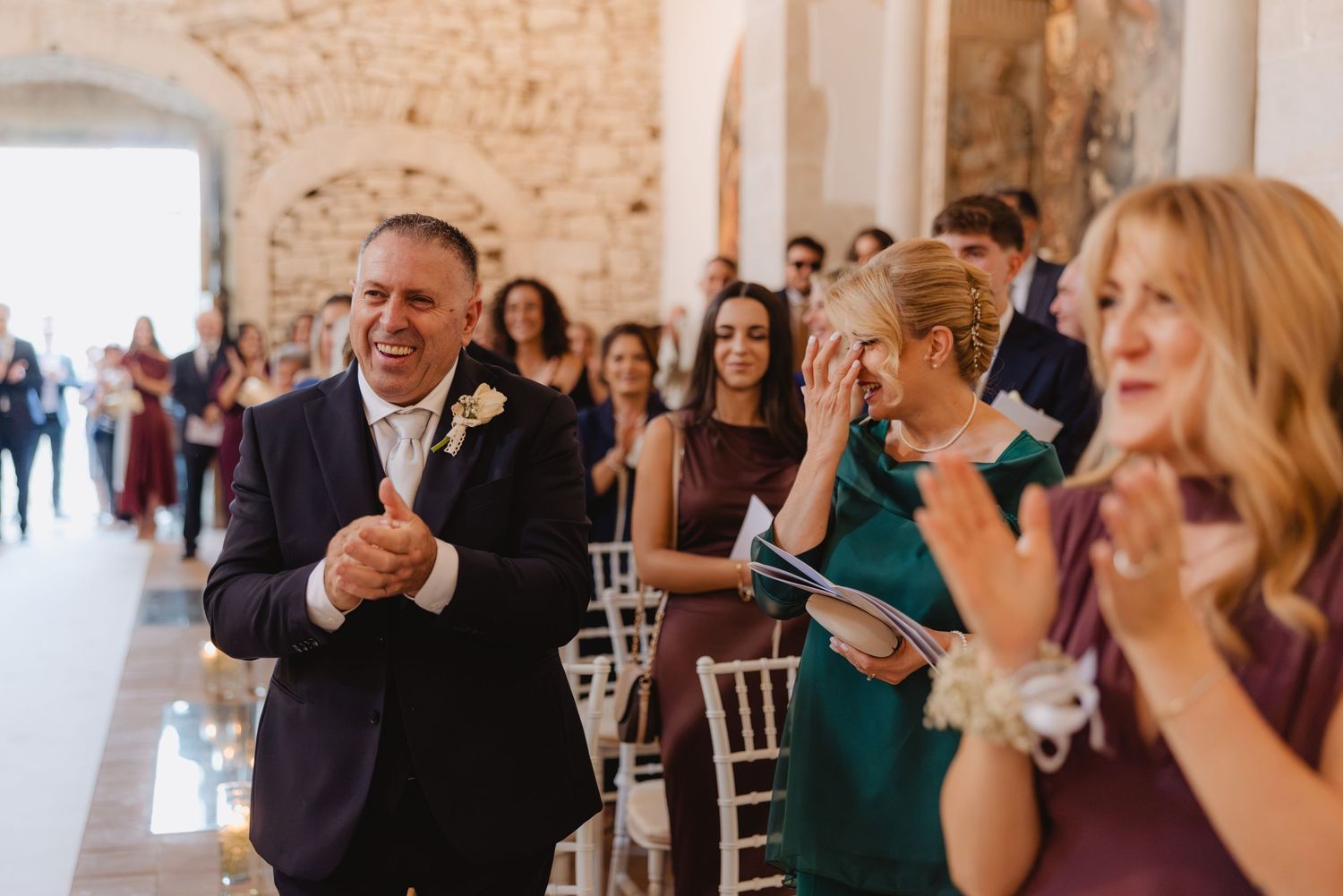 Gli invitati applaudono e sorridono durante la cerimonia.