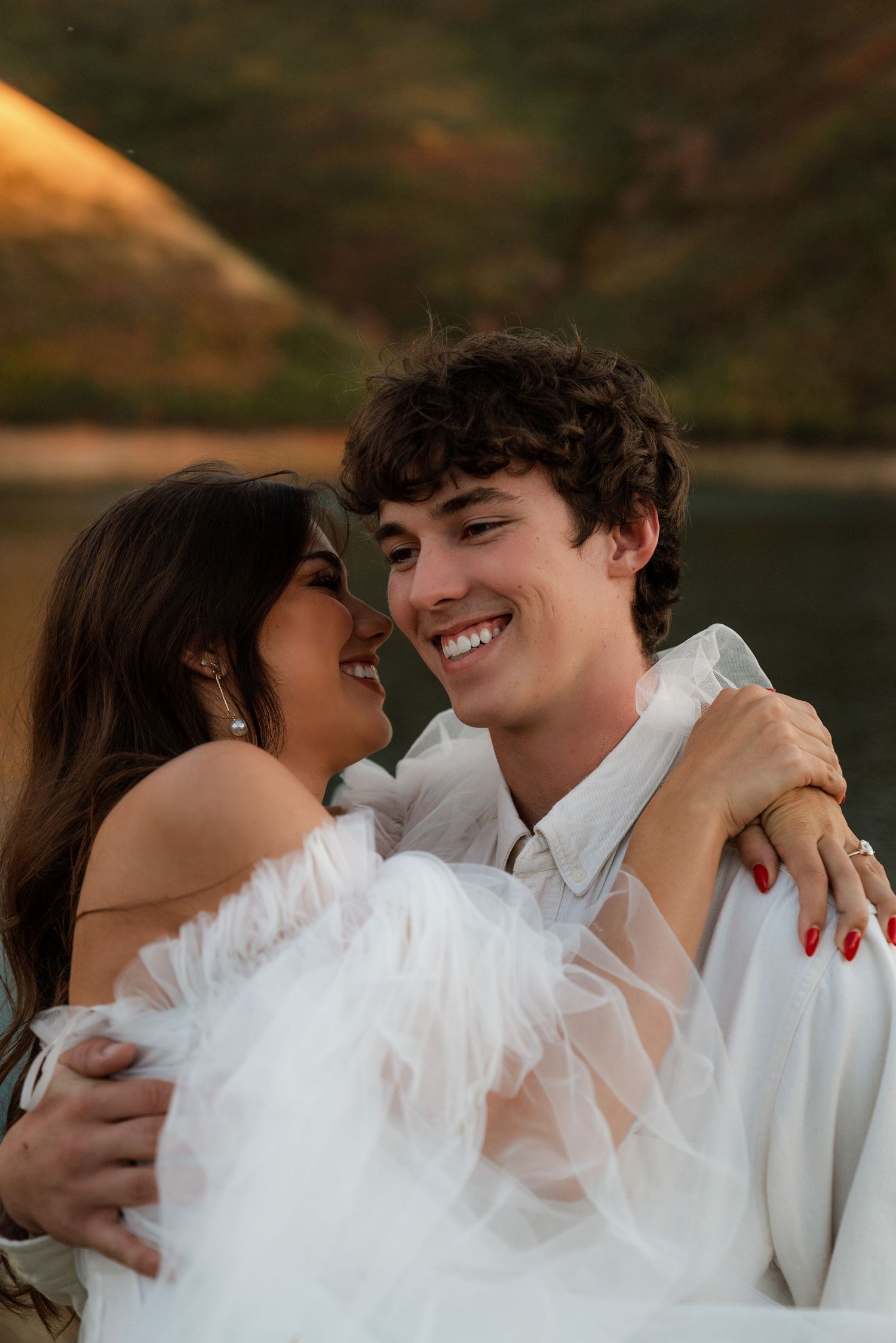 Influencer Meg Muise and fiance Sam Thomas holding each other wearing white modern clothes for North Carolina fall engagement photos
