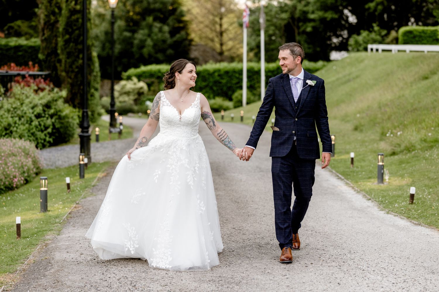 Bride and groom enjoying an evening stroll on the driveway at Broadoaks Country House