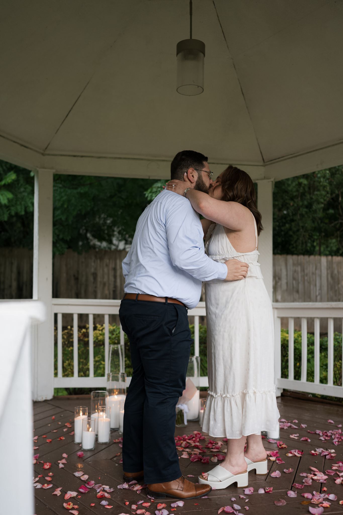 Couple sharing a kiss after the surprise proposal.