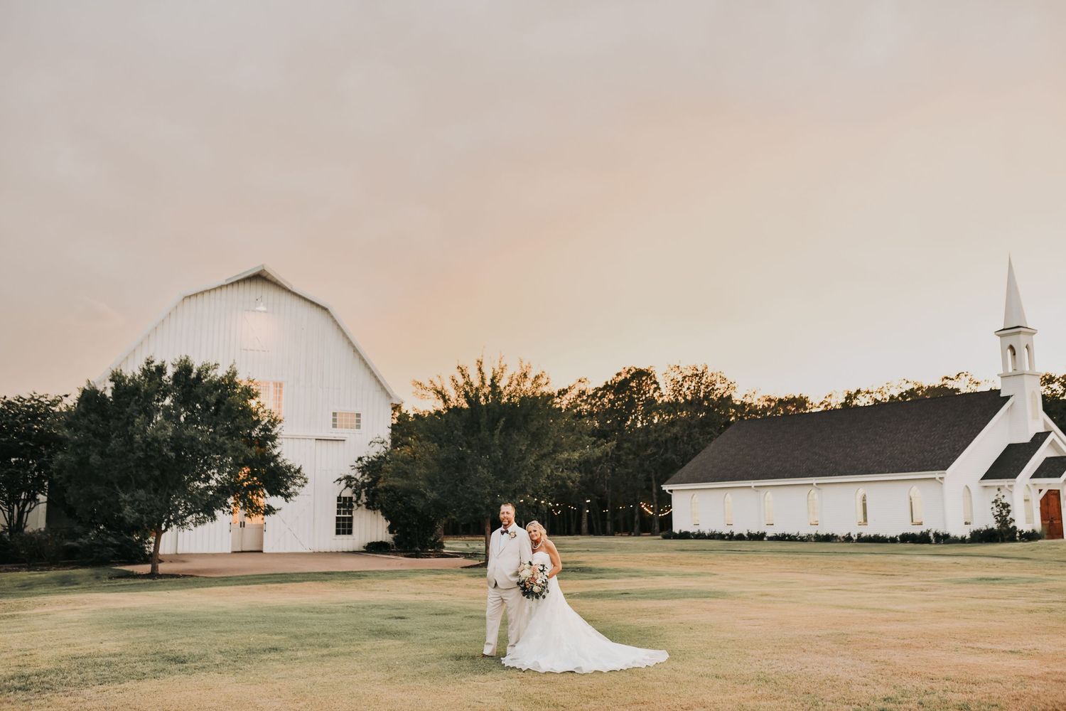 The White Sparrow chapel glowing in the background during sunset wedding portraits