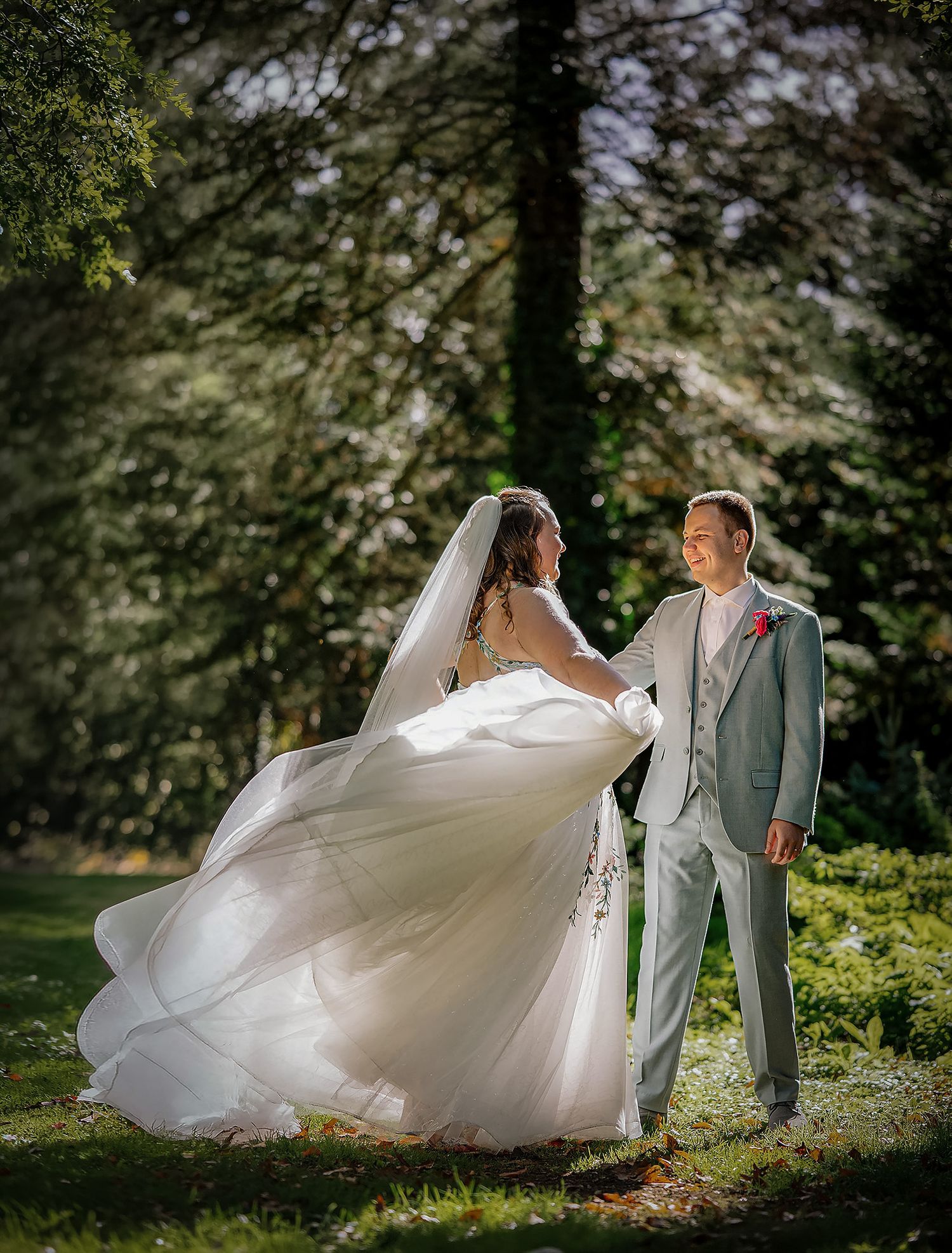 Sfeervolle bruidsfotografie van een bruid en bruidegom tijdens een romantisch moment in het bos.